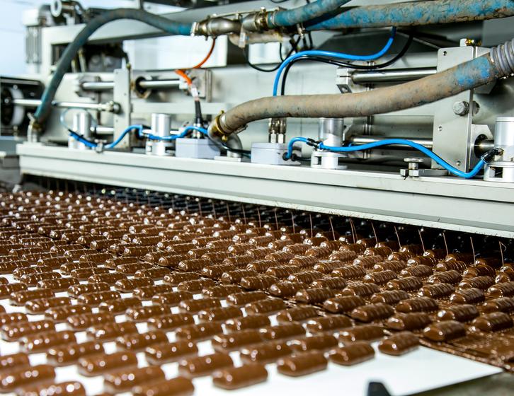 Rows of chocolate bars moving along a conveyor belt on an automated factory production line