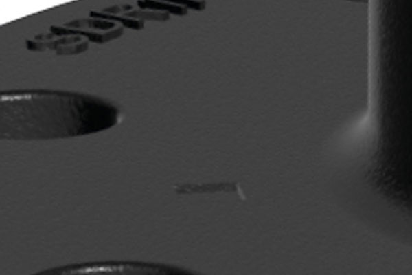 Close-up of a textured black metal base plate with embossed lettering and mounting hole
