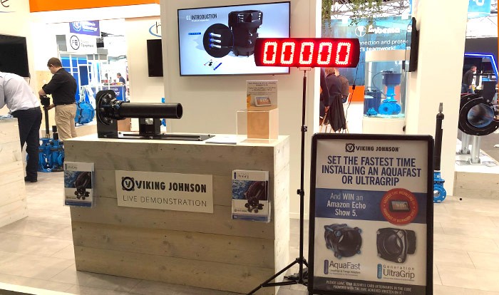 Viking Johnson trade show stand featuring a live demonstration counter, digital timer, and pipe installation competition sign