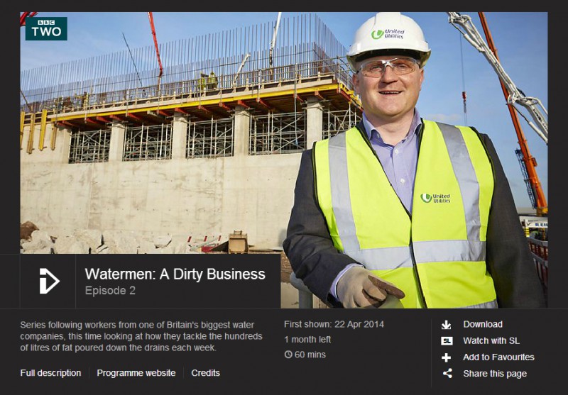 A United Utilities worker wearing a hard hat and hi-vis vest at a construction site