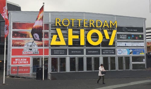 Exterior entrance to the Rotterdam Ahoy venue featuring large yellow signage above glass doors