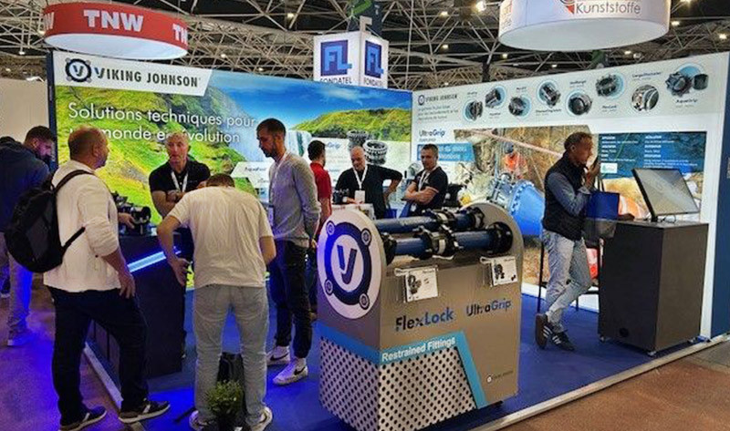 Visitors and staff gathered at the Viking Johnson trade show exhibition stand displaying industrial pipe fittings