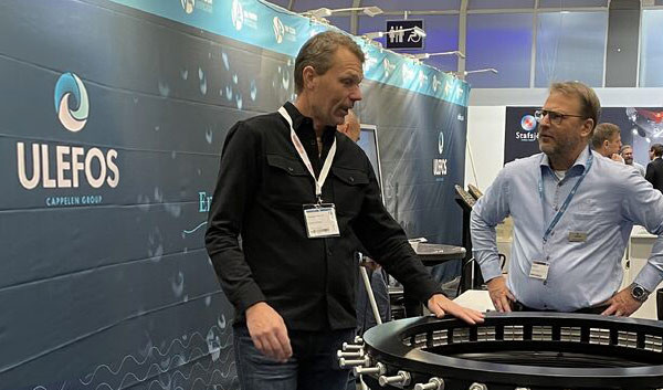 Two men discussing an industrial component at a Ulefos exhibition stand