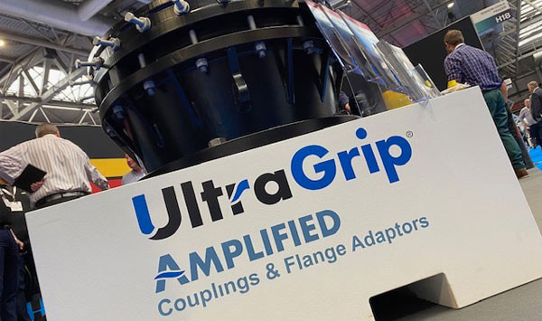 Large black UltraGrip pipe coupling on a display stand reading UltraGrip Amplified Couplings & Flange Adaptors