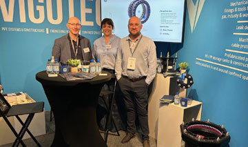 Three representatives standing at the Vigotec exhibition stand