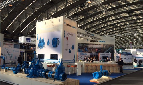 Imbema Denso exhibition stand displaying blue industrial valves and pipeline equipment at a trade fair