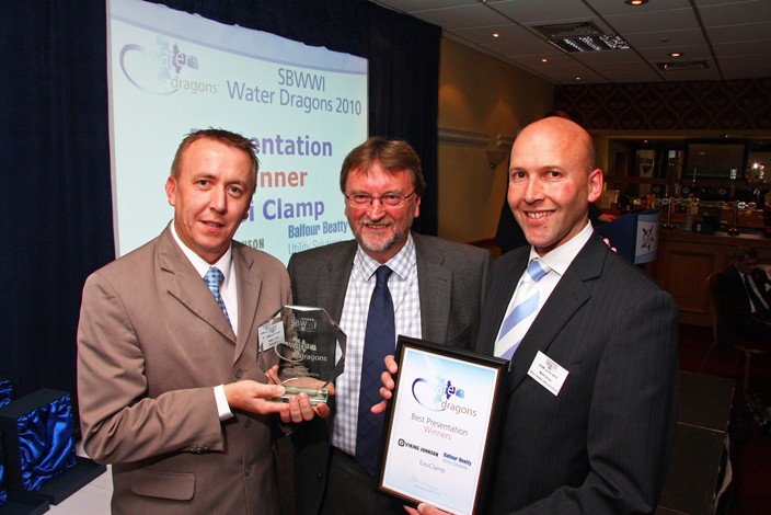 Three men holding the Best Presentation award certificate and glass trophy at the SBWWI Water Dragons 2010 event