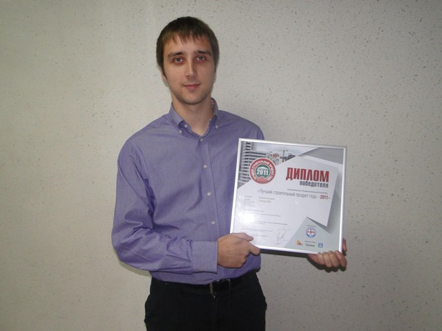Young man holding a framed award certificate for Best Construction Product of the Year 2011