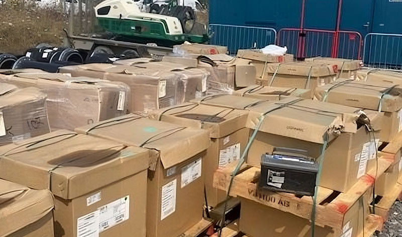 Large cardboard boxes strapped to wooden pallets outdoors at an industrial site