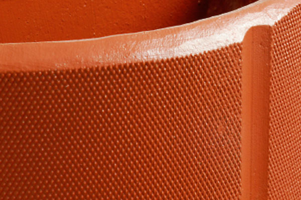 Close-up of the textured, diamond-patterned surface of an orange terracotta object