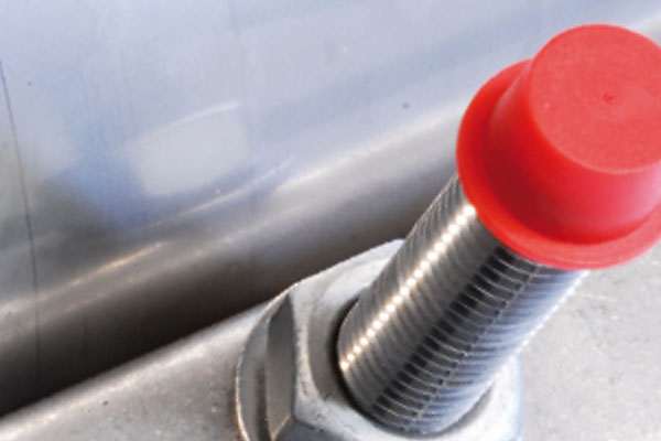 Threaded metal sensor with a red plastic protective cap secured by a nut