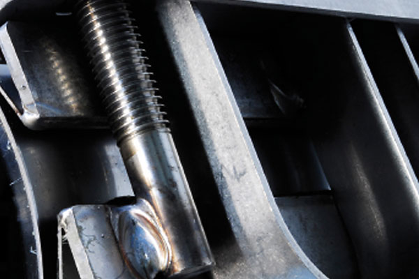 Close-up of a threaded metal bolt welded to a steel frame
