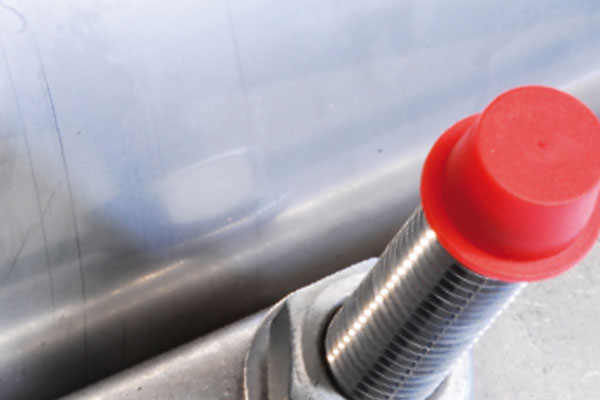 Threaded industrial sensor fitted with a bright red protective cap