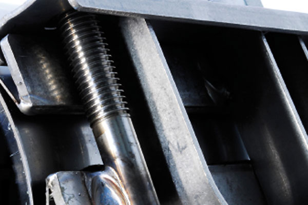 Close-up of a threaded steel bolt secured within a heavy-duty metal frame