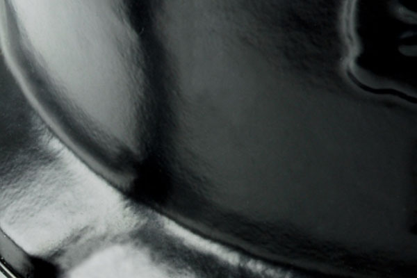 Close-up of a glossy, reflective black enamel surface