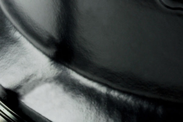 Smooth, reflective black surface with soft light highlights and curved contours