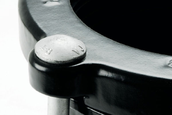 Close-up of a silver bolt head securing a black metal pipe coupling