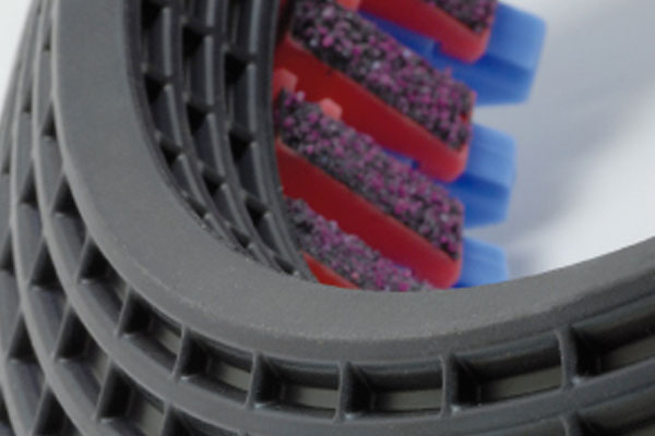 Close-up of a toothbrush head featuring colourful bristles and a grey textured frame