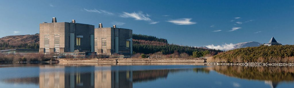 Trawsfynydd nuclear power station's twin concrete reactor buildings reflected in Llyn Trawsfynydd reservoir