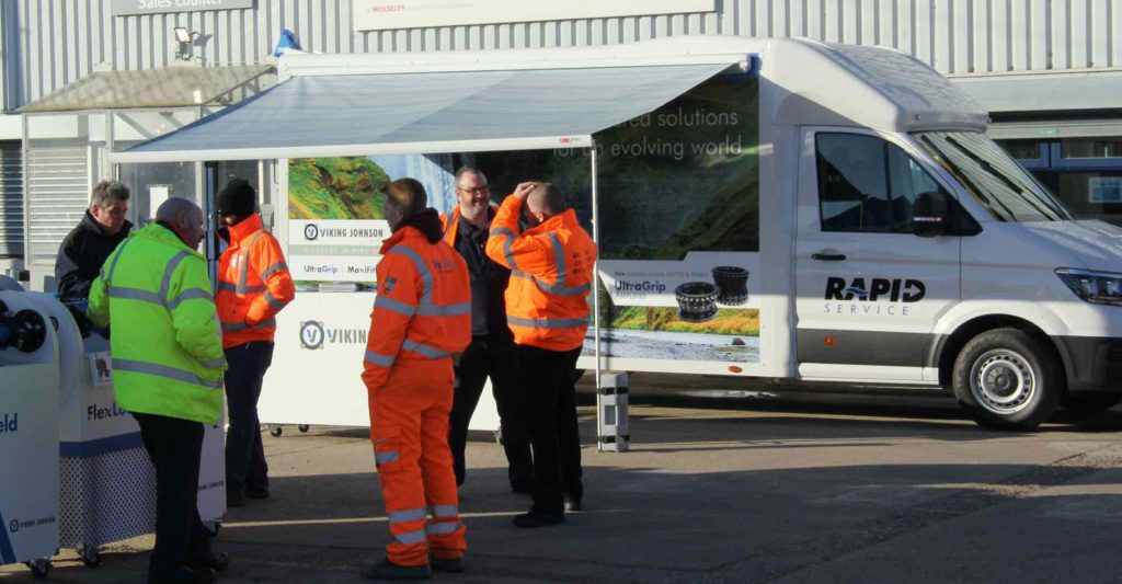 People in high-visibility jackets talking outside a Viking Johnson Rapid Service mobile display van