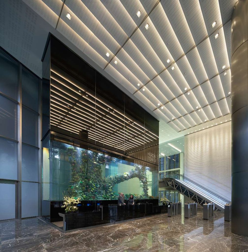 Heron Tower lobby featuring a large coral aquarium behind the reception desk