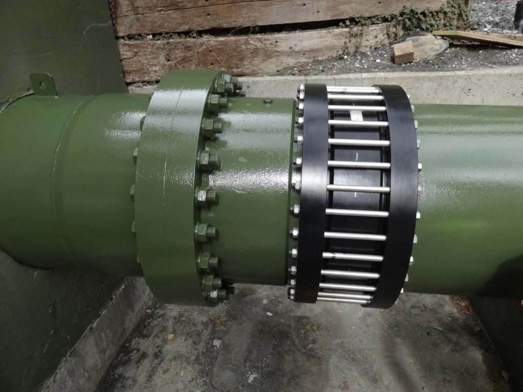 Bolted flange connection and modular seal assembly on a large green industrial pipe